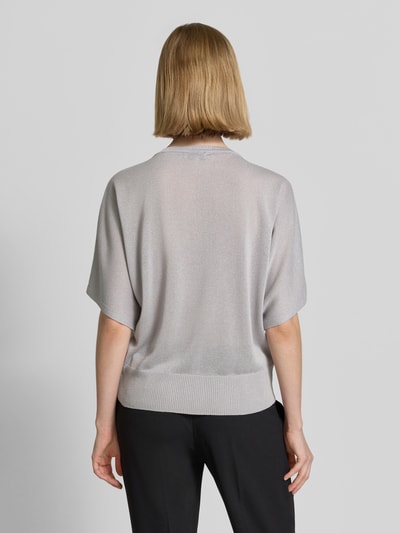 Frauenmodel trägt Relaxed Fit Oberteil aus Viskose-Mix in Strick-Optik von More & More, graue Farbe, elastischer Bund, Halbarm, Rückenlänge 56 cm, Ganzkörperansicht Rückansicht.
