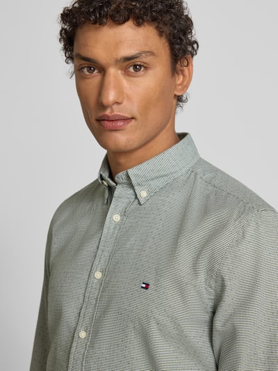 Męski model nosi Slim Fit Freizeithemd aus reiner Baumwolle od Tommy Hilfiger, efekt: wzór na całej powierzchni, popelina, koszula o kroju slim fit, kołnierzyk typu button down, długi rękaw, mankiety zapinane na 1 guzik, zapięcie na guziki, przód, półzbliżenie.