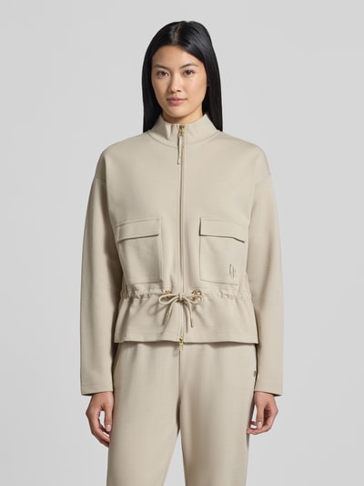 Vrouwenmodel draagt Regular fit sweatjack van katoenmix Regular Fit Sweatjacke aus Baumwoll-Mix van JOOP! Dames, sandkleur, zachte structuur, grote zakken, goudkleurige details, voorkant, volledige lichaamsopname