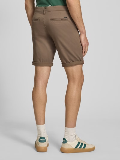 Männermodel trägt Regular Fit Shorts mit Eingrifftaschen Modell 'BOWIE' von Jack & Jones aus Baumwoll-Elasthan-Mix in Braun, Ganzkörperansicht Rückansicht.