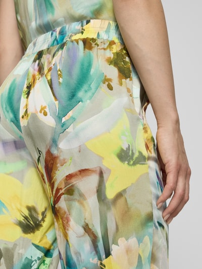 Frauenmodel trägt Stoffhose aus Viskose im Allover-Look von Betty Barclay, bunte florale Farben, elastischer Bund, Nahaufnahme Oberschenkel, Reine Viskose, Verkürzte Passform, Bundweite bei Größe 36: 39 cm, Innenbeinlänge bei Größe 36: 70 cm.