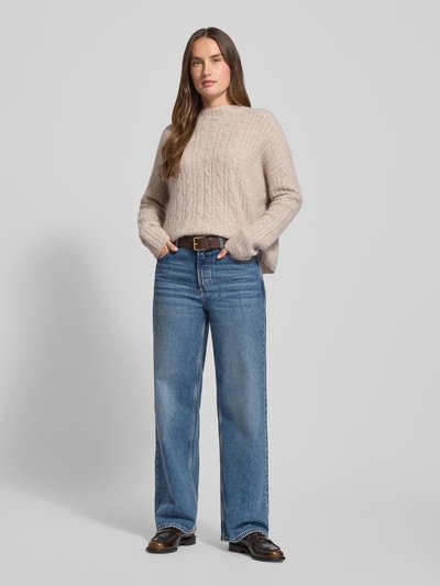 Frauenmodel trägt Relaxed Fit Strickpullover mit Schurwoll-Mix von Marc O’Polo in Melange-Optik mit Zopfstrick-Muster, Ganzkörperansicht von vorne.