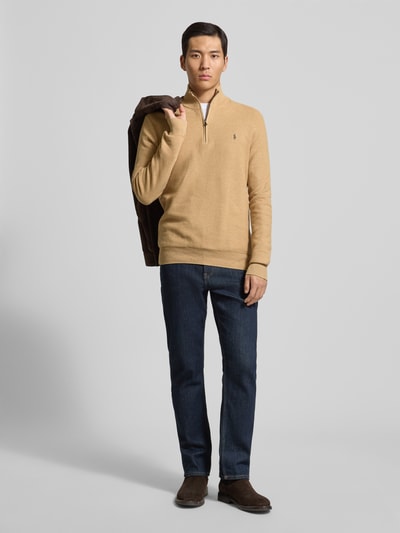 Männermodel trägt Regular Fit Troyer mit Label-Stitching von Polo Ralph Lauren in Beige aus reiner Baumwolle mit gerippten Abschlüssen, Troyer-Kragen und kurzem Reißverschluss, Ganzkörperansicht von vorne.