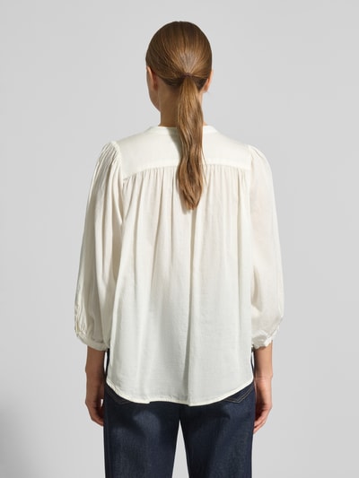 Frauenmodel trägt Regular Fit Bluse mit Rundhalsausschnitt Modell 'FAVIOLA' von 0039 Italy, reine Baumwolle, 3/4-Arm, Rückenlänge 65 cm, Ärmellänge 47 cm, in Creme mit lockerer Struktur, Ganzkörperansicht Rückansicht.