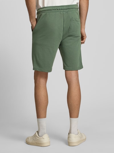 Männermodel trägt grüne Sweatshorts mit elastischem Bund Modell 'KARLOS' von Blend, Baumwoll-Mix, Regular Fit, Ganzkörperansicht Rückansicht.