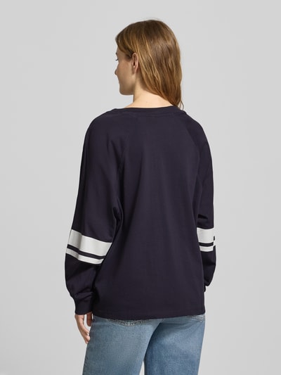 Männermodel trägt Loose Fit Langarmshirt aus reiner Baumwolle von Marc O'Polo Denim, unifarben mit Kontraststreifen, Ganzkörperansicht Rückansicht.