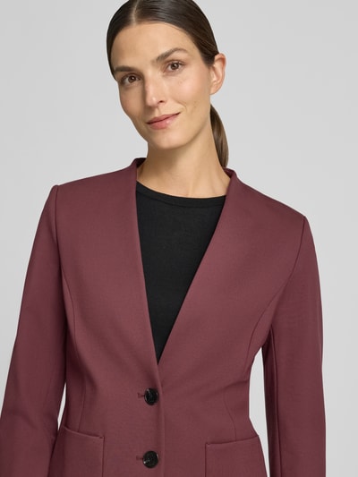 Vrouwenmodel draagt Regular Fit Kurzblazer aus Viskose-Mix van Jake*s Collection in bordeaux met zwarte knopen, Nahaufnahme bovenlichaam.