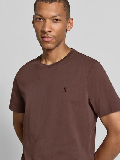 Männermodel trägt Regular Fit T-Shirt aus reiner Baumwolle Modell 'JAAMES' von ARMEDANGELS in Braun, glatte Struktur, Nahaufnahme Oberkörper.