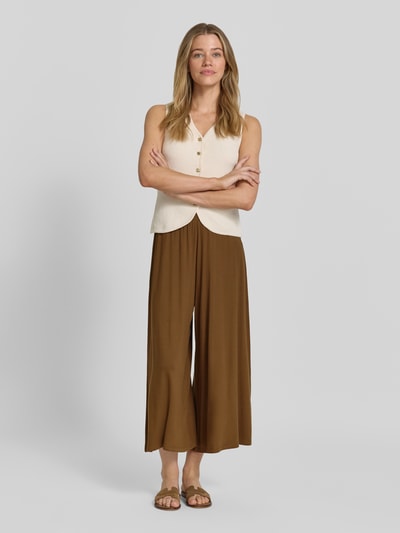 Frauenmodel trägt Wide Leg Culotte aus Viskose-Mix von Armedangels in Braun, lockerer Culotte-Stil, glatte Textur, Ganzkörperansicht von vorne, Damen Culotte von Armedangels.