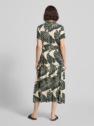 Vrouwenmodel draagt Hemdblusenkleid aus Viskose mit Bindegürtel van Christian Berg Woman in groen/beige bladmotief, getailleerd model, midi-jurk, overhemdkraag, knoopsluiting, mouwen met vaste omslag, strikceintuur, ruglengte maat 36: 117 cm, borstwijdte maat 36: 45 cm, mouwlengte maat 36: 18 cm. Ganzkörperaanzicht achteraan.