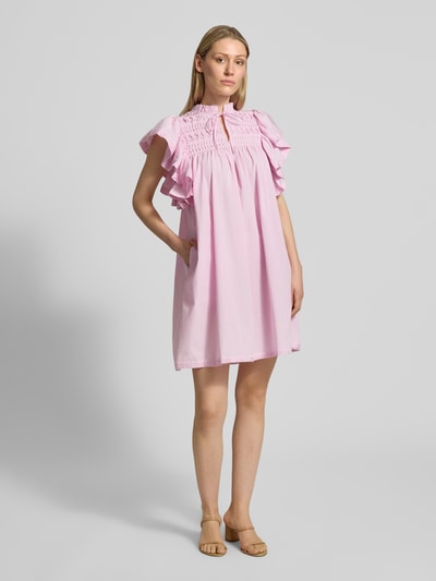 Frauenmodel trägt Minikleid mit Schmetterlingsärmel Modell 'LURA' von YAS in Lila, aus Material-Mix mit Baumwoll-Anteil, Straight Fit, Serafino-Kragen mit Schnürung, Rückenlänge 88 cm, Brustweite 55 cm, Ärmellänge 15 cm, Ganzkörperansicht von vorne.