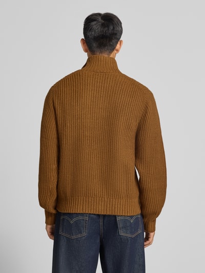 Männermodel trägt Troyer mit Brustleistentasche Modell 'DETROIT' von Carhartt Work In Progress, braun, grobe Strickstruktur, Ganzkörperansicht Rückansicht. Material-Mix mit Woll-Anteil, Regular Fit, Troyer-Kragen, Label-Patch, Rückenlänge 68 cm, Ärmellänge 56 cm.