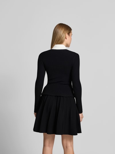 Frauenmodel trägt Minikleid aus Viskose-Mix von Self-Portrait in Schwarz mit Strick-Optik, Ziersteinbesatz, langärmelig, Ganzkörperansicht Rückansicht.