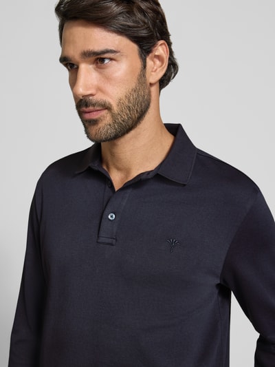 Mannelijk model draagt donkerblauw modern fit poloshirt uit pure katoen Modern Fit Poloshirt aus reiner Baumwolle model '01Perolo' van JOOP! collectie, close-up bovenlichaam.
