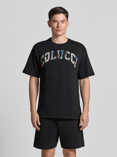 Männermodel trägt T-Shirt mit 1/2-Arm von COLUCCI in Schwarz, reine Baumwolle, gerader Schnitt, Rundhalsausschnitt, Ganzkörperansicht von vorne.