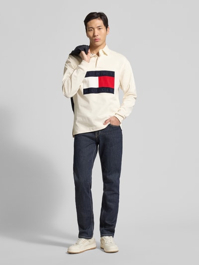 Männermodel trägt Regular Fit Sweatshirt aus reiner Baumwolle von Tommy Hilfiger in Unifarbe mit Polokragen und Label Patch, Ganzkörperansicht von vorne.