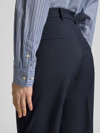 Frauenmodel trägt Hose in verkürzter Passform Modell 'KRYSTAL' von Cambio in Dunkelblau, strukturierte Oberfläche, Detailaufnahme Rückansicht. Damen Hose Regular Fit, Eingrifftaschen, Bundweite 42 cm, Innenbeinlänge 69 cm bei Größe 36.