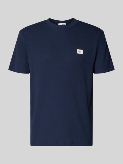 Produktfoto, Regular Fit T-Shirt mit Logo-Patch von Calvin Klein Jeans aus Baumwoll-Mix, dunkelblau mit Strukturmuster und Rundhalsausschnitt.