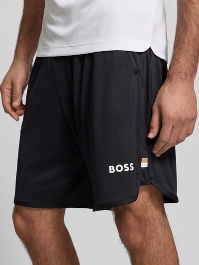 Männermodel trägt Regular Fit Shorts mit Label-Schriftzug Modell 'TOC SPIN 9 INCH' von BOSS Green, unifarben, Nahaufnahme Oberschenkel.