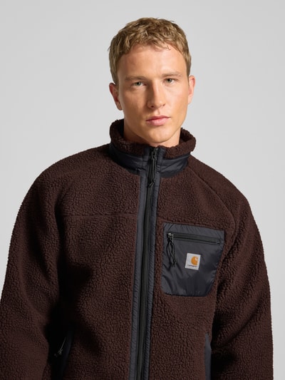 Männermodel trägt Fleecejacke mit Brusttasche Modell 'PRENTIS LINER' von Carhartt Work In Progress, braun, Nahaufnahme Oberkörper.