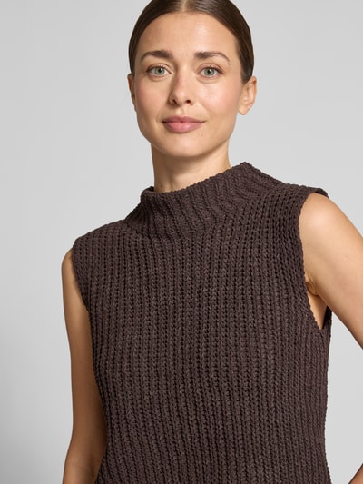 Vrouwenmodel draagt Slim Fit Pullunder mit Stehkragen van monari in bruine gebreide look, mouwloos, lengte 50 cm bij maat 36, Nahaufnahme Oberkörper.
