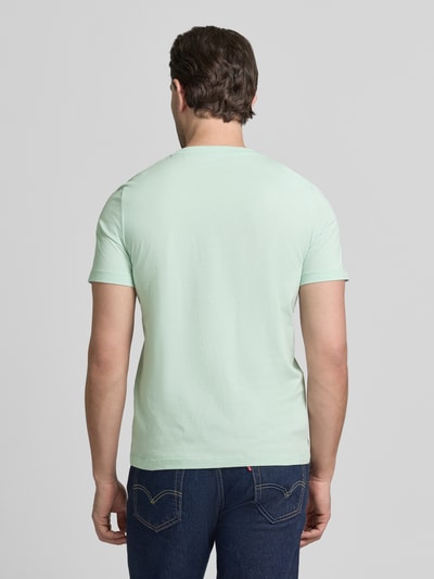 Męski model nosi Regular Fit T-Shirt aus reiner Baumwolle von s.Oliver RED LABEL, gładka mięta, jersey, krój regular fit, widok z tyłu, cała sylwetka.