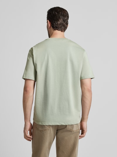 Männermodel trägt Oversized T-Shirt mit Rundhalsausschnitt von Lindbergh in Hellgrün aus reiner Baumwolle, Rückansicht Ganzkörperansicht.