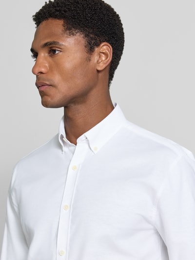 Männermodel trägt Regular Fit Freizeithemd aus Baumwoll-Mix Modell 'Oxford' von Lindbergh in Weiß, Nahaufnahme Oberkörper. Rückenlänge 77 cm, Schulterbreite 44 cm, Ärmellänge 66 cm, Button-Down-Kragen, 1-Knopf-Manschetten, abgerundeter Saum.
