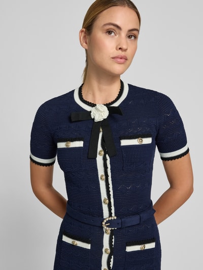 Frauenmodel trägt Slim Fit Midikleid in Strick-Optik von Self-Portrait, dunkles Blau, cremefarbene Details, Knopfleiste, Baumwoll-Mix, Nahaufnahme Oberkörper. Gesamtlänge 126 cm, Brustweite 41 cm, Ärmellänge 23 cm, Taillenweite 34 cm.