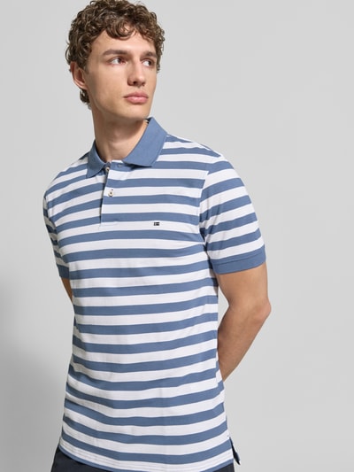 Männermodel trägt Modern Fit Poloshirt mit Logo-Stitching von Christian Berg Men, gestreift in Blau und Weiß, reine Baumwolle, Ganzkörperansicht von vorne.