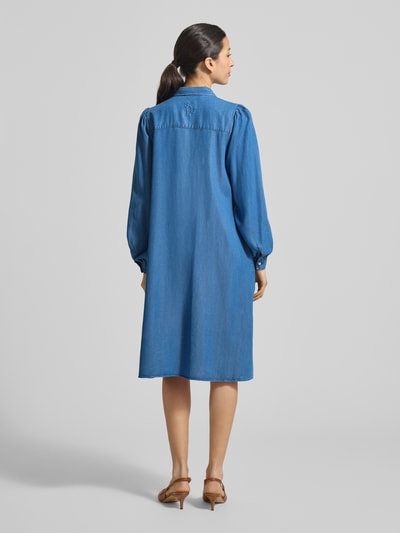 Kobiece modelka nosi Knielanges Hemdblusenkleid in Denim-Optik von Smith & Soul, czysty lyocell, prosty krój, długość do kolan, tkanina stylizowana na denim, kołnierzyk koszulowy, listwa guzikowa, długość tyłu w rozmiarze S 104 cm, szerokość w rozmiarze S 49 cm, długość rękawów w rozmiarze S 65 cm, całkowity widok z tyłu.