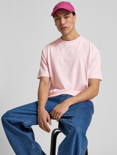 Männermodel trägt Regular Fit T-Shirt aus reiner Baumwolle von Closed in Rosa, mit Rundhalsausschnitt und Label-Print, Used-Look, Nahaufnahme Oberkörper. Herren T-Shirt, Rückenlänge bei Größe M 76 cm.