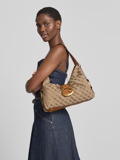 Vrouwenmodel draagt Handtasche mit Logo-Muster Modell 'CAMDEN' van GUESS in beige met bruin, all-over look, draagband, schouderband, hoofvak met ritssluiting, breedte 37 cm, lengte 26 cm, diepte 10 cm, bandlengte 48 cm, logomotief, detailopname zijaanzicht.
