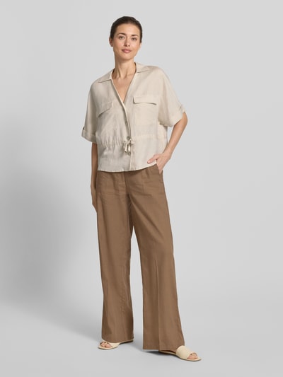 Kobiece model prezentuje Hemdbluse aus Leinen-Viskose-Mix od Christian Berg Woman Selection, beżowa, prosty krój, kieszenie, sznurek w talii, półdługie rękawy, długość tyłu w rozmiarze 36: 56 cm, szerokość w rozmiarze 36: 55 cm, długość rękawa w rozmiarze 36: 28 cm, gładka tekstura, widok całofigurowy z przodu.