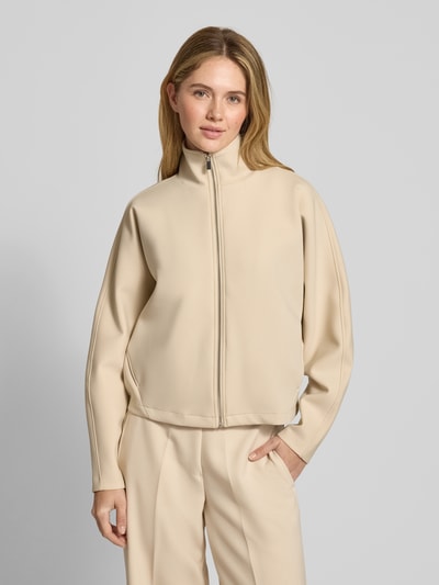 Vrouwenmodel draagt Jacke mit Stehkragen Modell 'Ulara' van Someday, materiaalmix met stretch, los model, opstaande kraag, ritssluiting, zijzakken, ruglengte 54 cm, schouderbreedte 43 cm, borstwijdte 60 cm, mouwlengte 61 cm, kleur lichtbeige, gladde structuur, voorkant volledige lichaamsopname.