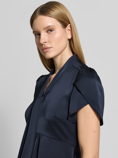 Frauenmodel trägt Midikleid mit V-Ausschnitt und Schluppe von Christian Berg Woman Selection aus dunkelblauem Satin, Schmetterlingsärmel, Nahaufnahme Oberkörper.
