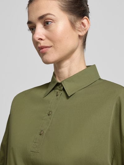 Frauenmodel trägt Regular Fit Bluse mit Polokragen von Marc Cain in Khaki, reine Baumwolle, elastische Ärmelabschlüsse, Nahaufnahme Oberkörper.