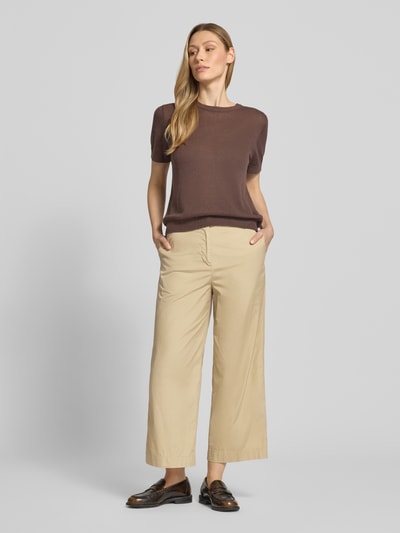 Frauenmodel trägt Hose in verkürzter Passform mit Eingrifftaschen von Gant, Reine Baumwolle, beiger Farbton, Ganzkörperansicht von vorne.