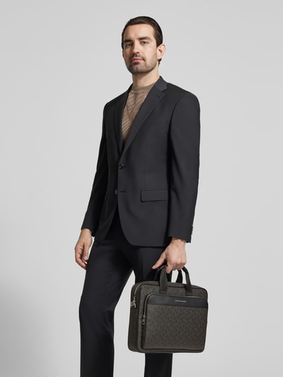 Männermodel trägt Laptoptasche mit Allover-Muster Modell 'MONOGRAM' von Tommy Hilfiger, Optik: Unifarben, Kunstleder, Rechteckig, Ganzkörperansicht von vorne.
