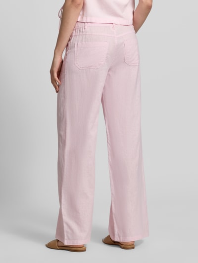 Frauenmodel trägt Mid Waist Hose aus Leinen-Baumwoll-Mix von Gina Tricot in zartem Rosa, weites Bein, Eingrifftaschen, Tunnelzug, Ganzkörperansicht Rückansicht.