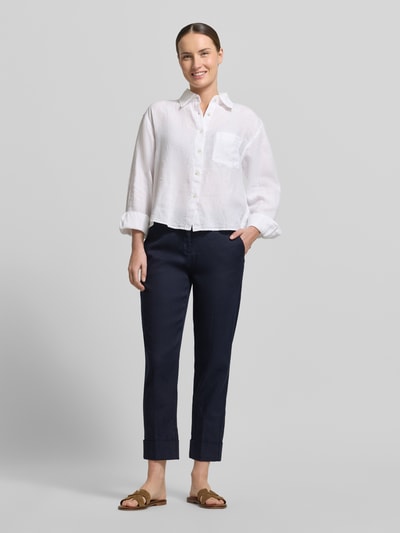 Frauenmodel trägt Leinenhose mit Baumwoll-Anteil von Cambio, Modell Krystal, dunkelblau, Straight Fit, verkürzte Passform, umgeschlagene Beinabschlüsse, mit Gürtelschlaufen, Knopf- und Reißverschluss, Eingriff- und Gesäßtaschen, elastischer Mix, glatte Textur; Ganzkörperansicht von vorne.