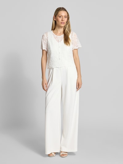 Kobiece model prezentuje Regular Fit Jumpsuit mit Spitzenbesatz od Vera Mont, biały, elastyczna mieszanka materiałów, cekinowe obszycie, krótki rękaw, listwa guzikowa, okrągły dekolt, krój regular fit, całkowita długość 157 cm, długość wewnętrzna nogawki 81 cm, Ganzkörperansicht von vorne.