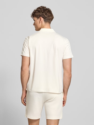 Männermodel trägt Regular Fit Poloshirt mit Logo-Stitching Modell 'EGEO' von SERGIO TACCHINI in creme, glatte Struktur, Ganzkörperansicht Rückansicht.