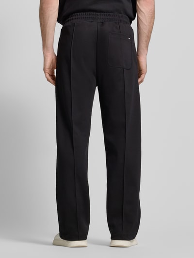 Mężczyzna nosi Regular Fit Sweatpants aus Baumwoll-Mix Model 'DINETO' od HUGO, efekt: jednolity kolor, naszywka z logo, kanty, elastyczny ściągacz z tunelem, wpuszczane kieszenie i kieszeń z tyłu, wykończenie: dzianina dresowa, mieszanka bawełny, całkowity widok z tyłu.
