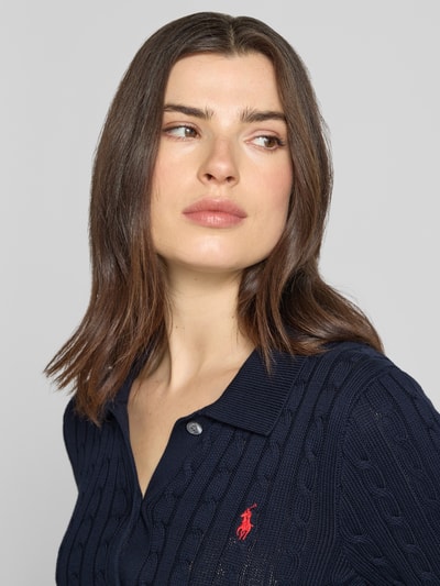 Vrouwenmodel draagt Slim Fit gebreid jack uit puur katoen van Polo Ralph Lauren, effen kleuren, kabelpatroon, gestikt logo, overhemdkraag, knoopsluiting, lange mouwen, geribde mouw- en rompzoom, knitwear, donkerblauw, materiaalverwerking: puur katoen. Nahaufnahme bovenlichaam.