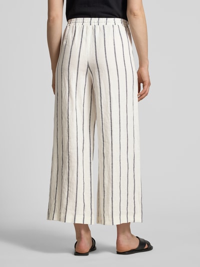 Frauenmodel trägt Straight Fit Leinenhose aus reinen Leinen Modell 'Callie' von MAC mit schwarzen Längsstreifen, lockere Textur, verkürzte Passform, elastischer Bund, Ganzkörperansicht Rückansicht.