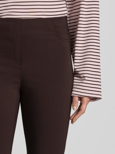 Frauenmodel trägt Caprihose aus Viskose-Mix Modell 'Igor3' von STEHMANN, dunkelbraun, mit elastischem Bund, Nahaufnahme Oberkörper.