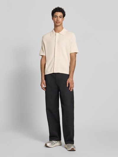 Männermodel trägt Regular Fit vrijetijdsoverhemd uit puur katoen van Marc O'Polo Denim in effen kleuren, knitweartextuur en labelpatch, polokraag, V-hals, knoopsluiting, korte mouw, geribde mouwboord en rompzoom, geheel van voren.
