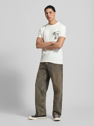 Männermodel trägt Regular Fit T-Shirt aus reiner Baumwolle von Tommy Jeans, Optik: Unifarben, Label-Print, Ganzkörperansicht von vorne.
