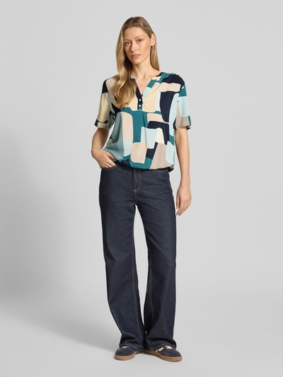 Frauenmodel trägt Regular Fit Blusenshirt aus reiner Viskose von Tom Tailor, mehrfarbiges Popeline-Material mit V-Ausschnitt, Ganzkörperansicht von vorne.